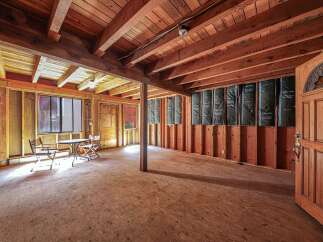 Explore the potential of this unfinished space, featuring exposed wooden beams and a rustic charm.