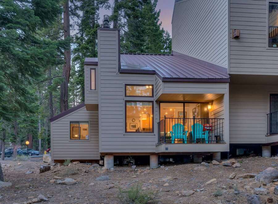 Nestled amongst tall pine trees, this charming home offers a serene mountain retreat.