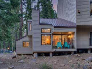 Nestled amongst tall pine trees, this charming home offers a serene mountain retreat.