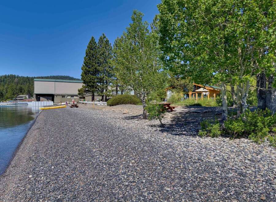 Enjoy lakeside living with this stunning property featuring a private pebble beach perfect for launching kayaks or simply relaxing by the water.