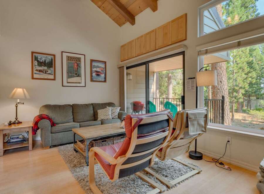 Experience cozy living in this charming mountain retreat, featuring a spacious living area with a comfortable sofa and accent chairs perfect for relaxing.