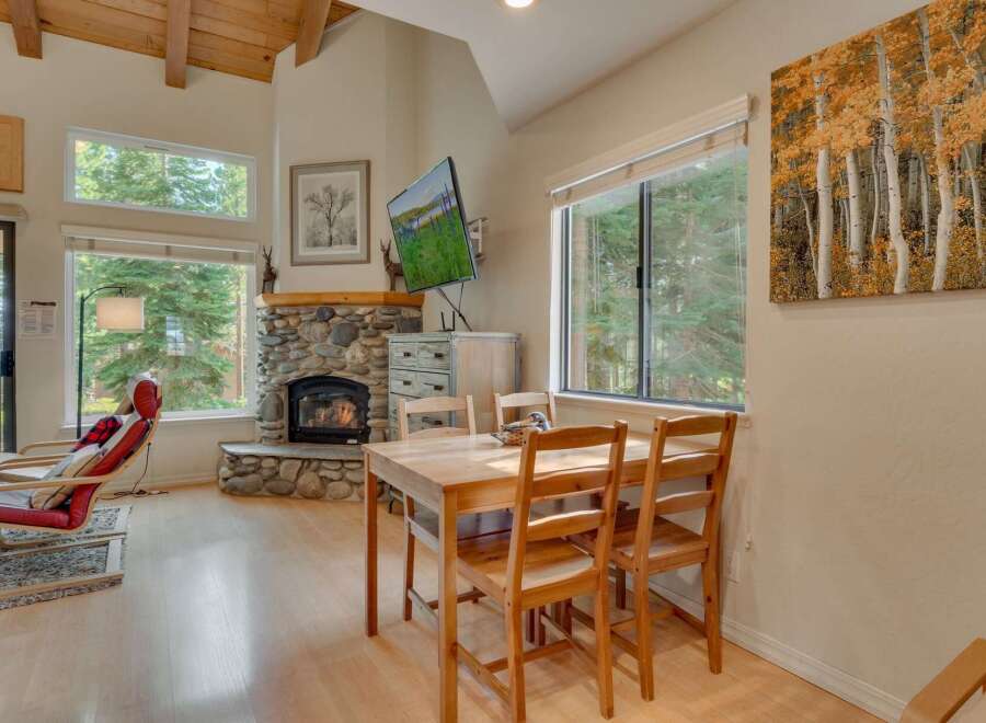 Experience cozy living in this charming mountain retreat, featuring a stunning stone fireplace and large windows that flood the space with natural light.