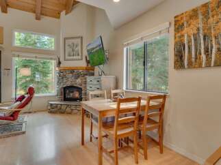 Experience cozy living in this charming mountain retreat, featuring a stunning stone fireplace and large windows that flood the space with natural light.