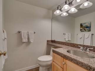 This bathroom features a clean and functional design with a white toilet and a vanity with a granite countertop.