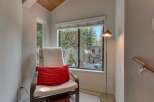 Relax and unwind in this cozy reading nook, complete with a comfortable chair and a plush red accent pillow.