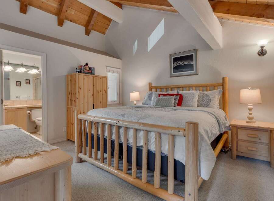 Experience rustic charm in this inviting bedroom featuring a sturdy log bed and a spacious wooden wardrobe.
