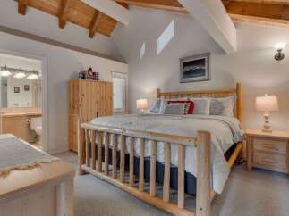Experience rustic charm in this inviting bedroom featuring a sturdy log bed and a spacious wooden wardrobe.
