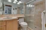 This bathroom features a spacious walk-in shower with glass doors and tiled walls, perfect for a relaxing experience.