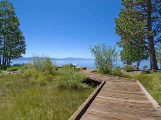 Enjoy breathtaking lake views from this charming property featuring a scenic wooden boardwalk leading to the water's edge.