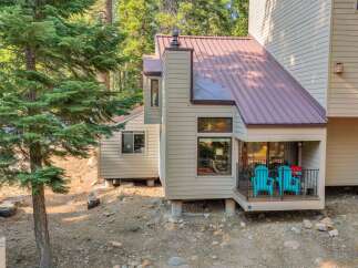Nestled amongst tall pine trees, this charming home offers a serene mountain retreat.