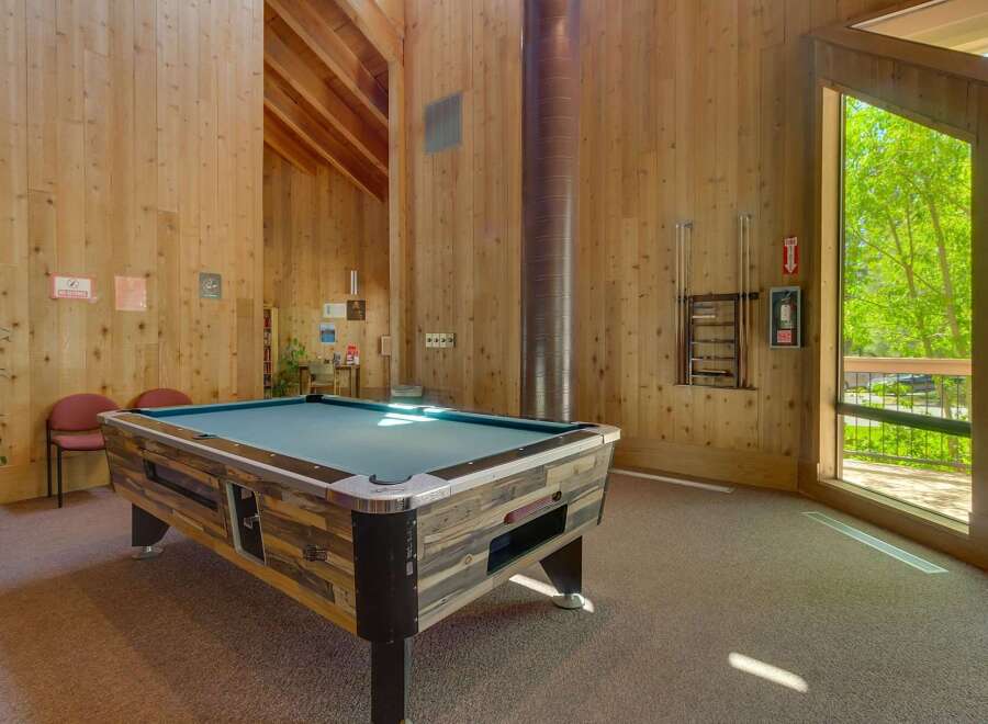 Enjoy a game of pool in this spacious recreation room, featuring a full-sized pool table and ample natural light.