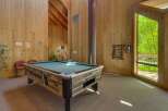 Enjoy a game of pool in this spacious recreation room, featuring a full-sized pool table and ample natural light.