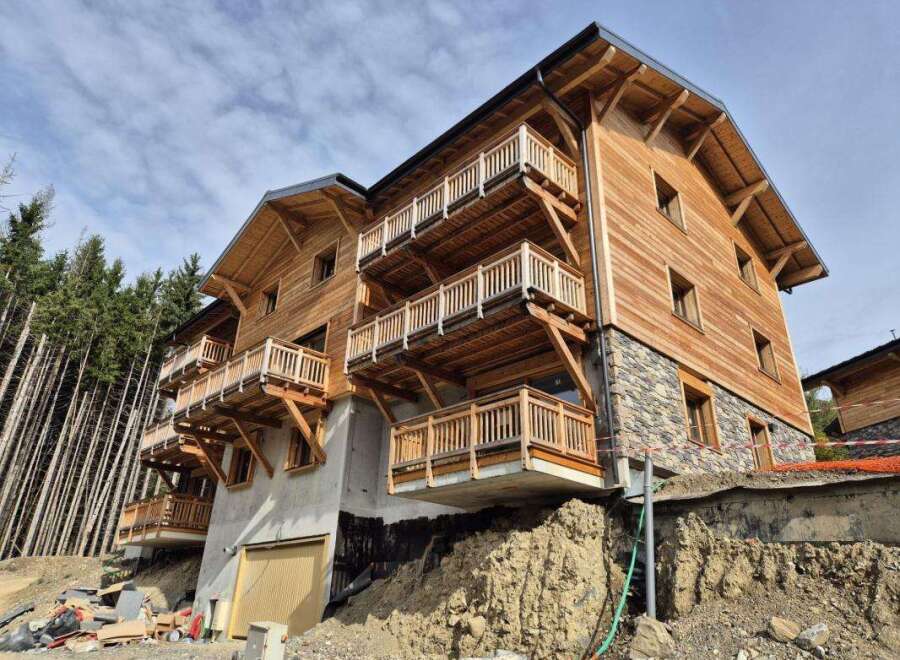 Discover this stunning wooden chalet-style property, featuring multiple levels of balconies offering breathtaking mountain views.