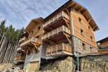 Discover this stunning wooden chalet-style property, featuring multiple levels of balconies offering breathtaking mountain views.
