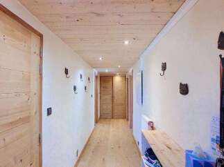 Step into this charming mountain chalet hallway, featuring warm wooden ceilings and floors that create a cozy, rustic ambiance.