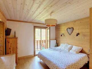 Experience cozy mountain living in this charming bedroom featuring a spacious bed with a decorative duvet and plush pillows.