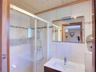 Experience modern comfort in this charming bathroom, featuring a spacious glass-enclosed shower and a sleek vanity with ample storage.