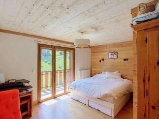 Experience cozy mountain living in this charming bedroom featuring a comfortable queen-sized bed with crisp white linens.