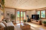 Experience cozy living in this charming mountain retreat, featuring a warm and inviting living space with a beautiful wooden ceiling and floors.