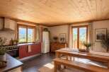Experience rustic charm in this inviting kitchen and dining area, featuring a warm wooden ceiling and ample natural light.