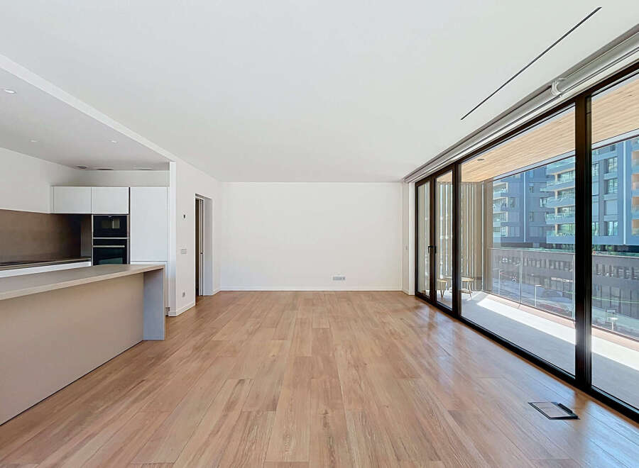 Experience modern living in this spacious, open-concept apartment featuring a sleek, integrated kitchen with built-in appliances.