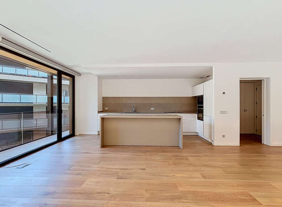 Experience modern living in this spacious open-plan apartment featuring a sleek, contemporary kitchen with an island and integrated appliances.
