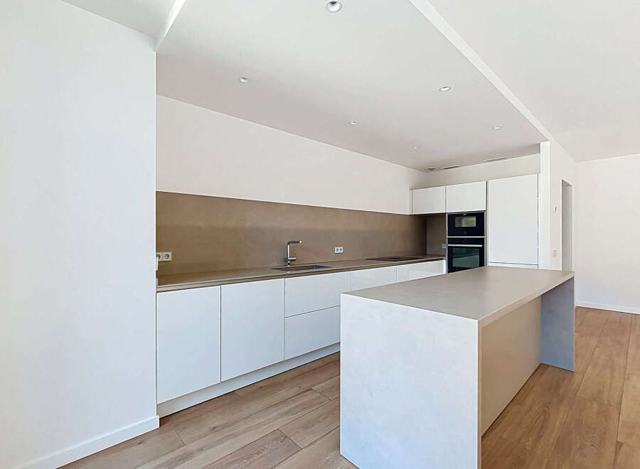Experience modern living in this stunning, newly renovated kitchen featuring sleek white cabinetry and a sophisticated taupe backsplash.