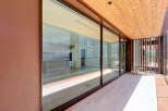 Experience luxurious indoor-outdoor living with expansive floor-to-ceiling glass doors that open onto a spacious balcony.