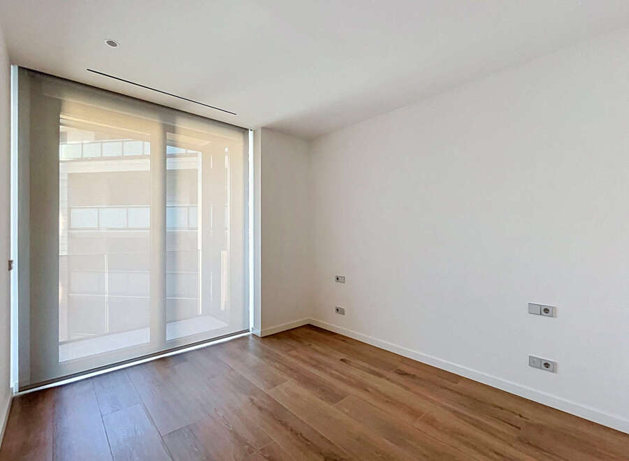 Experience modern living in this unfurnished room featuring a large sliding glass door that floods the space with natural light.