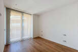 Experience modern living in this unfurnished room featuring a large sliding glass door that floods the space with natural light.
