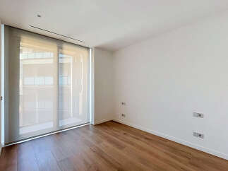 Experience modern living in this unfurnished room featuring a large sliding glass door that floods the space with natural light.