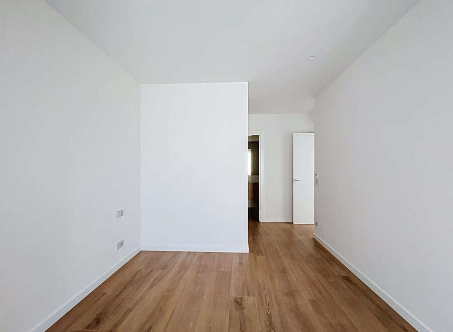 Step into this bright and airy space featuring pristine white walls and a beautiful wooden floor.