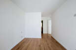 Step into this bright and airy space featuring pristine white walls and a beautiful wooden floor.