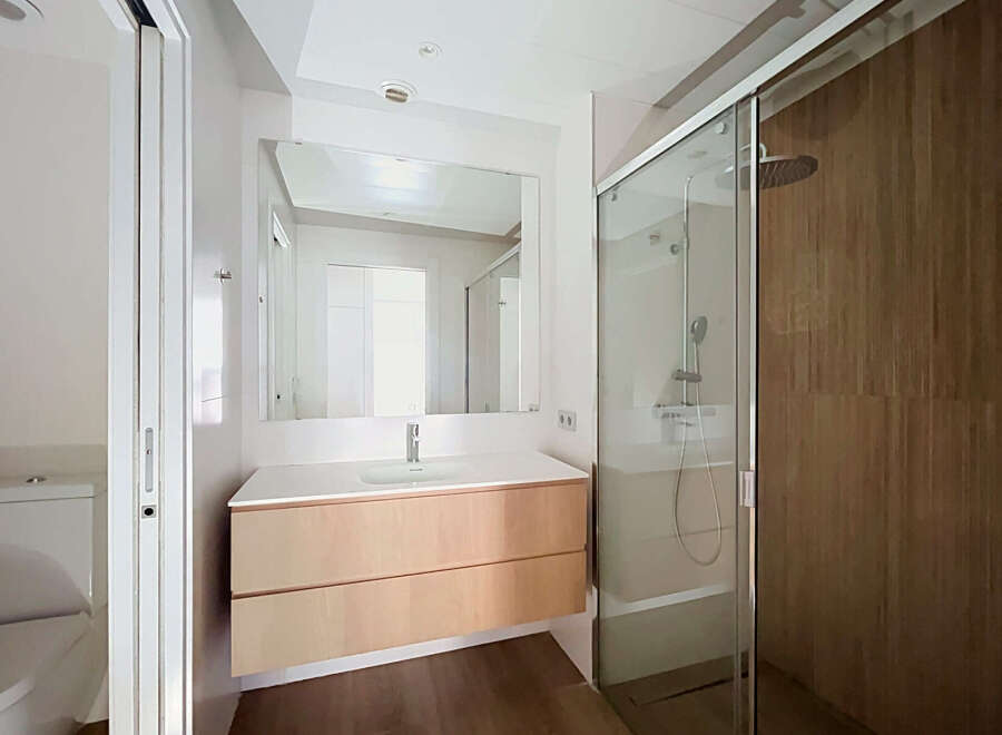 Experience modern comfort in this beautifully appointed bathroom, featuring a sleek vanity with ample storage and a pristine white countertop.