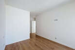 Discover this bright and airy room featuring pristine white walls and a beautiful wooden floor.
