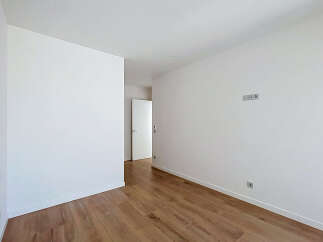 Discover this bright and airy room featuring pristine white walls and a beautiful wooden floor.
