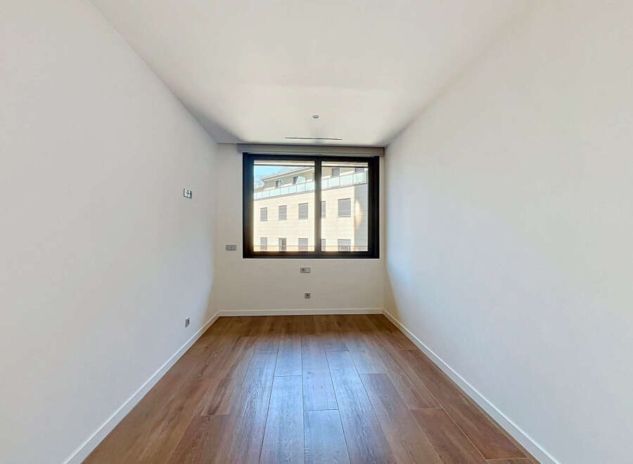 Discover this bright and airy room, featuring pristine white walls and elegant hardwood flooring that adds warmth and sophistication.