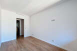This spacious room features a clean, modern aesthetic with white walls and a sleek air vent.