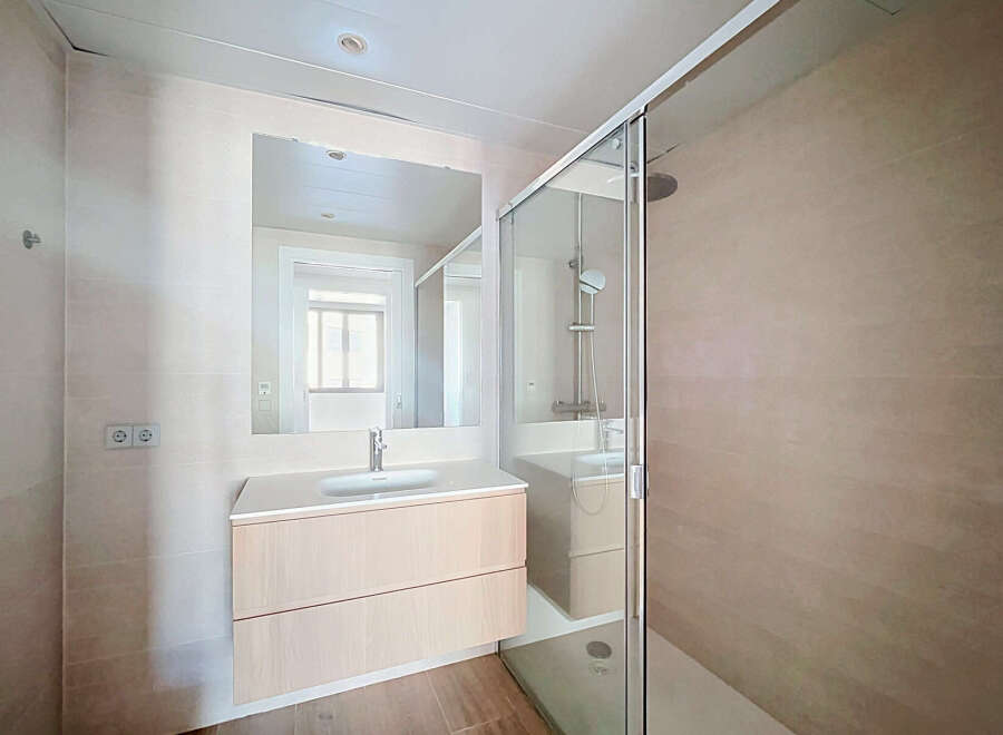Experience modern comfort in this beautifully appointed bathroom, featuring a sleek vanity with ample storage and a spacious walk-in shower with a rainfall showerhead.