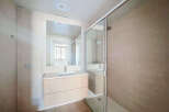 Experience modern comfort in this beautifully appointed bathroom, featuring a sleek vanity with ample storage and a spacious walk-in shower with a rainfall showerhead.
