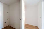 Discover this bright and airy space, featuring clean white tiled walls and a modern wooden floor.