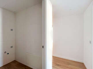 Discover this bright and airy space, featuring clean white tiled walls and a modern wooden floor.