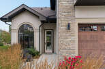 This stunning home features a beautiful arched window and a welcoming front door, perfect for greeting guests.