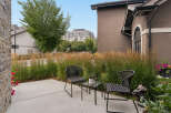 Enjoy your morning coffee on this charming patio, complete with two comfortable wicker chairs and a glass-top table.