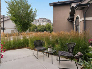Enjoy your morning coffee on this charming patio, complete with two comfortable wicker chairs and a glass-top table.