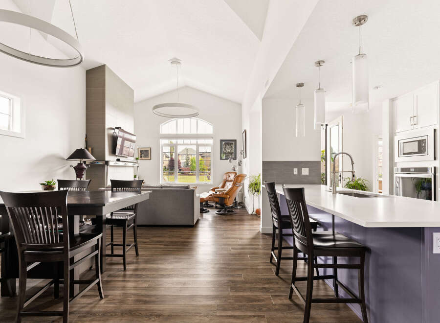 Experience modern living in this spacious open-concept home, featuring a gourmet kitchen with a large island and sleek white cabinetry, perfect for entertaining.