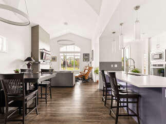 Experience modern living in this spacious open-concept home, featuring a gourmet kitchen with a large island and sleek white cabinetry, perfect for entertaining.