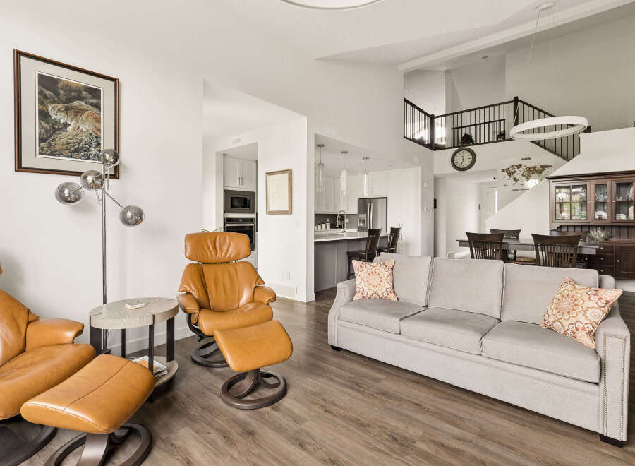 Experience modern living in this spacious open-concept home, featuring a bright living area with comfortable seating and a stylish accent pillow.