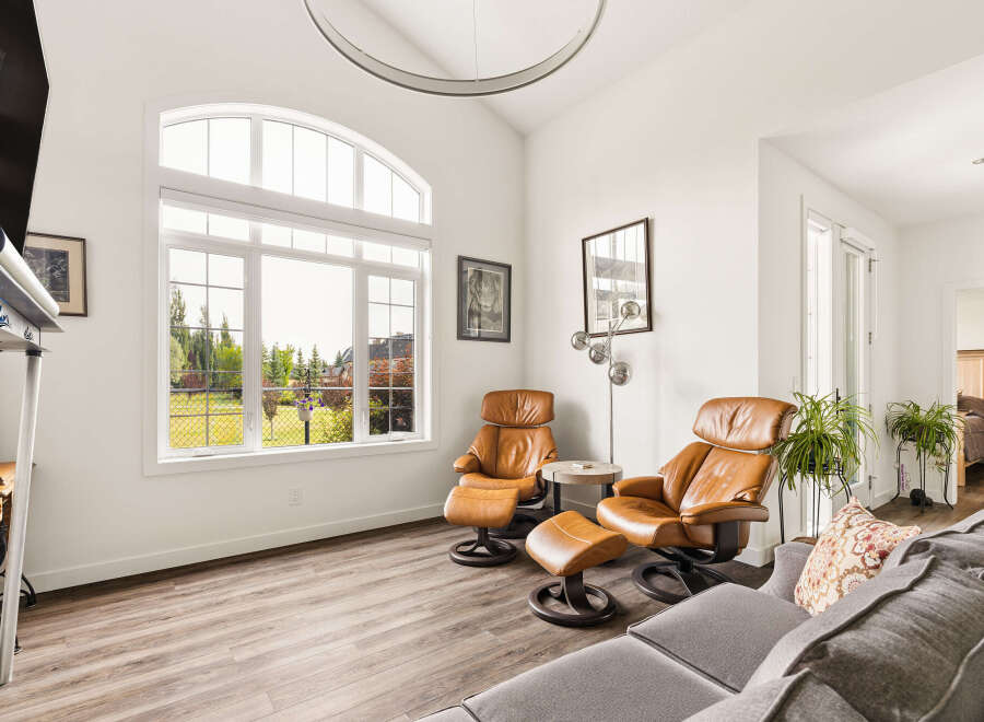 Experience luxury living in this spacious living room, featuring comfortable leather recliners and a large sectional sofa perfect for gatherings.