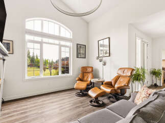 Experience luxury living in this spacious living room, featuring comfortable leather recliners and a large sectional sofa perfect for gatherings.